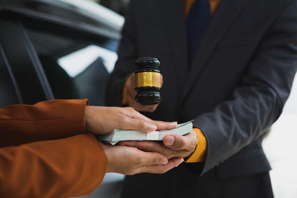 Person handing money to someone holding a judge’s gavel, symbolizing personal injury compensation and how timing can affect a legal claim.
