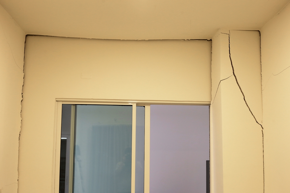 Severe cracks in apartment wall and ceiling showing dangerous conditions that require tenants to properly notify their landlord.