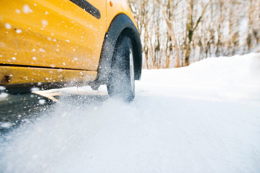 Vehicle tire driving through snow during winter car accidents in NJ, highlighting icy roads and injury risks.