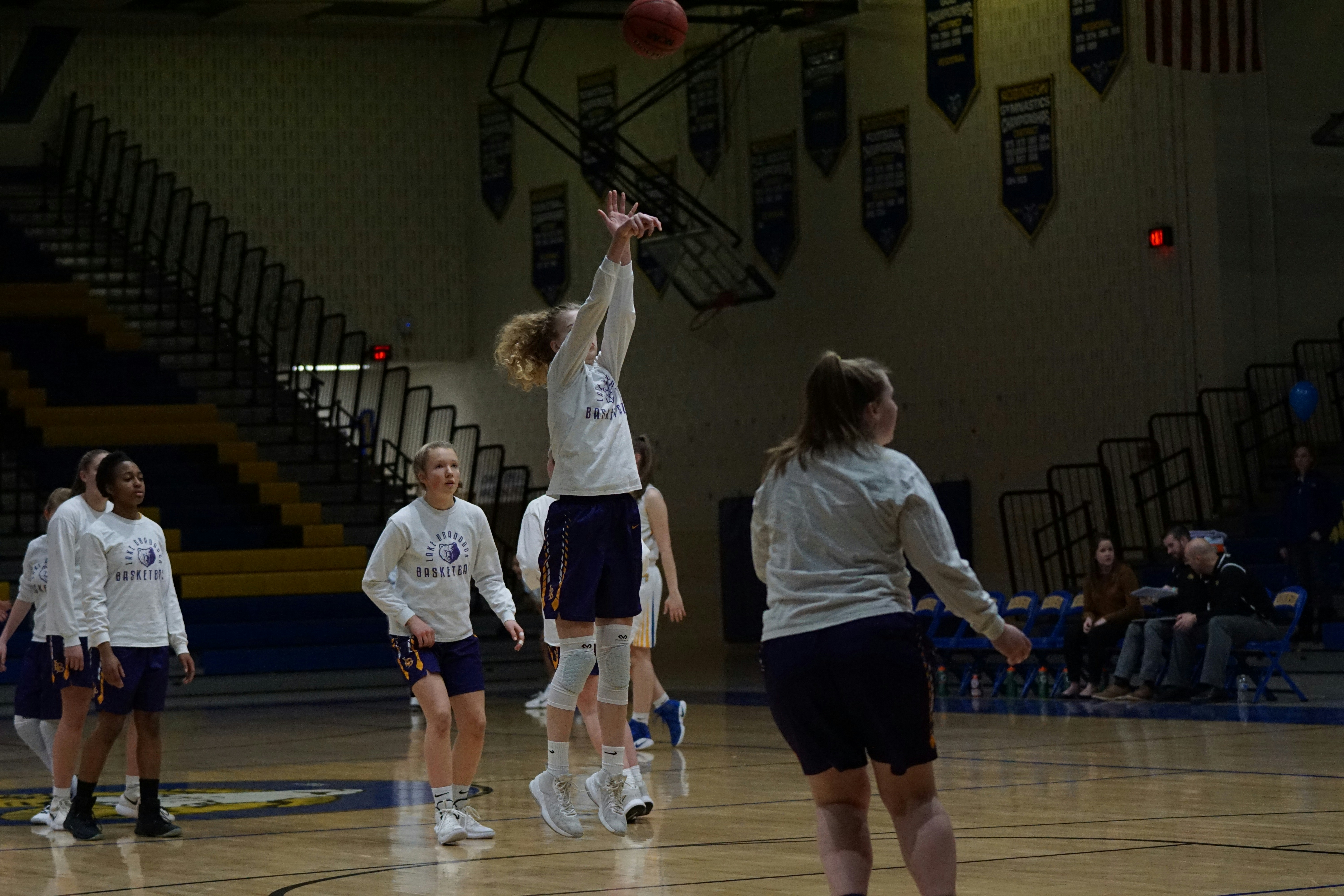 Youth basketball players warming up on a school court without protective eyewear, a common setting for sports eye injuries.